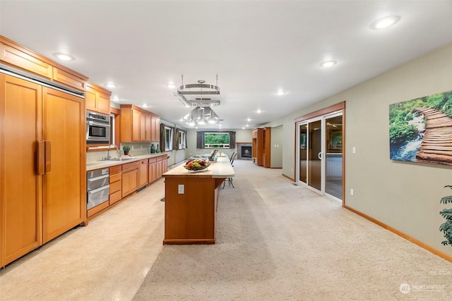 kitchen featuring a center island, recessed lighting, a sink, paneled built in refrigerator, and oven