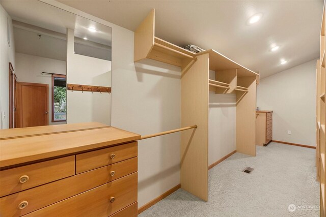 spacious closet featuring light colored carpet