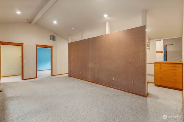 carpeted spare room with beamed ceiling and high vaulted ceiling