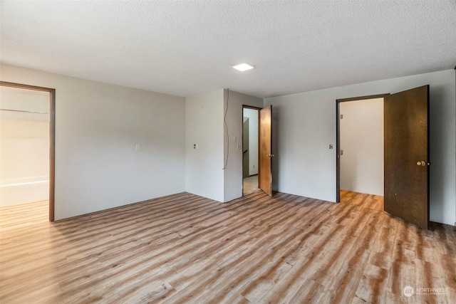 unfurnished bedroom featuring a textured ceiling and light wood-style flooring