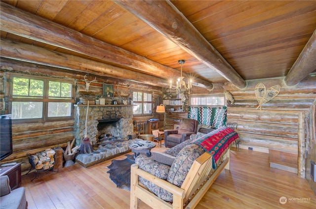 living room with log walls, a healthy amount of sunlight, a stone fireplace, and wood-type flooring