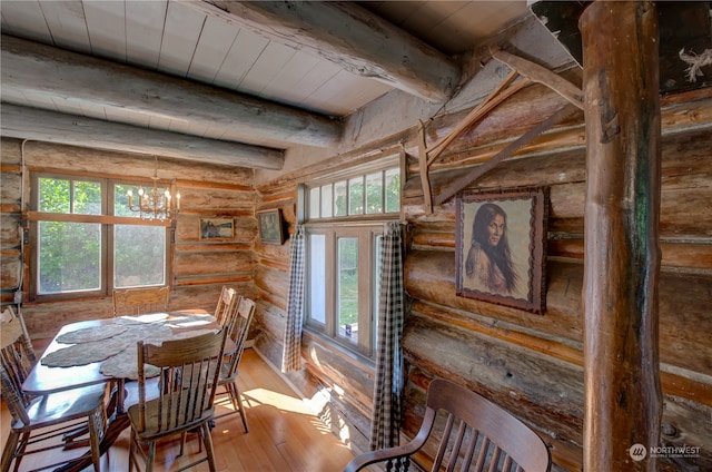 dining room featuring an inviting chandelier, hardwood / wood-style floors, wood ceiling, beamed ceiling, and rustic walls