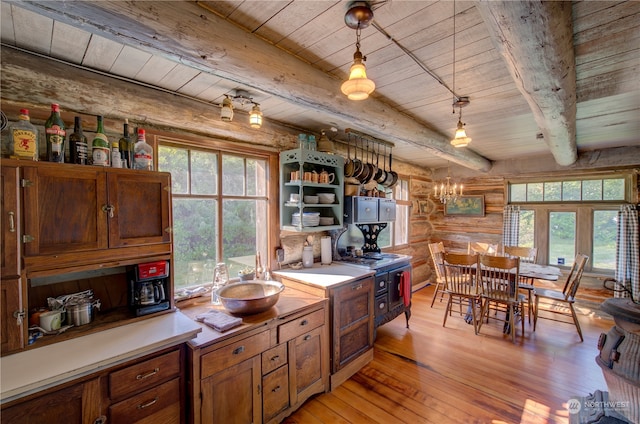 kitchen with beamed ceiling, pendant lighting, light hardwood / wood-style floors, wood ceiling, and rustic walls