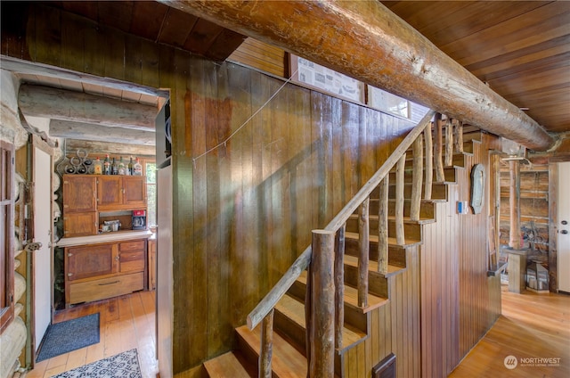 stairs with wood walls, wood-type flooring, and wooden ceiling