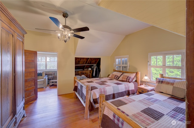 bedroom with light wood-type flooring, multiple windows, lofted ceiling, and ceiling fan