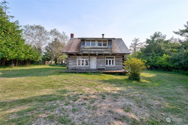 rear view of property featuring a yard and a wooden deck