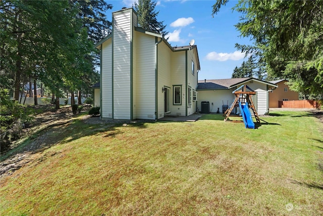 rear view of property with a yard and cooling unit