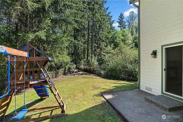 view of yard featuring a playground and a patio