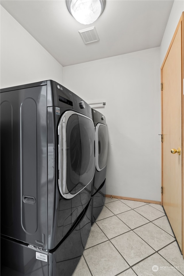 laundry room with separate washer and dryer and light tile patterned floors