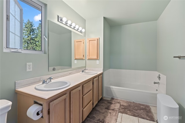 bathroom featuring vanity, toilet, a bathing tub, and tile patterned flooring