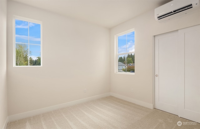 unfurnished bedroom with a closet, a wall unit AC, and light colored carpet