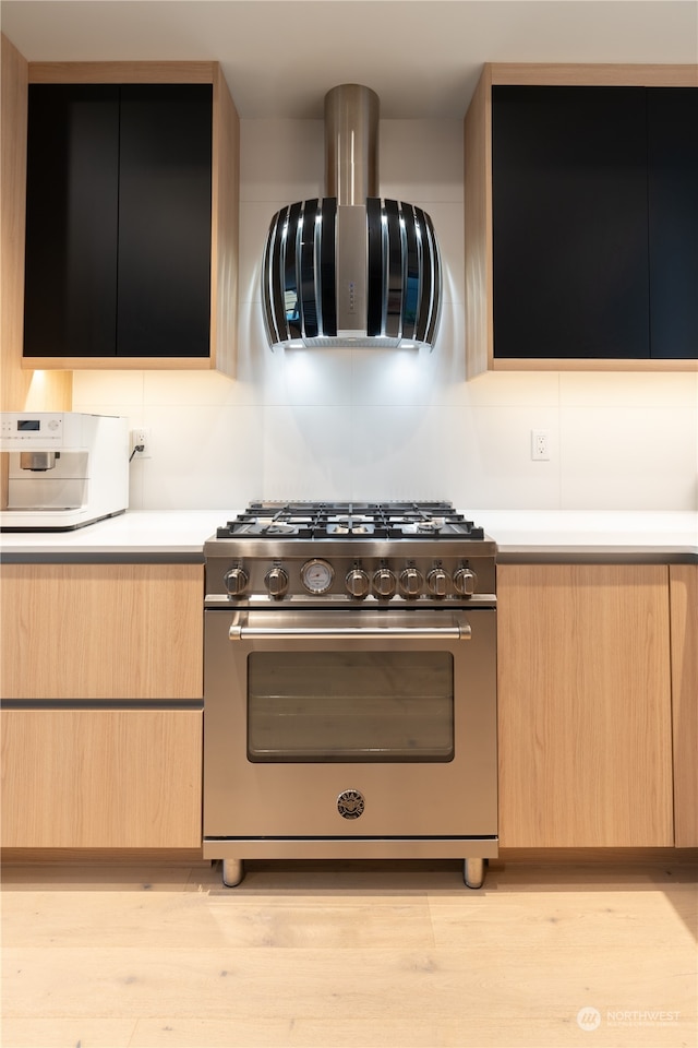 kitchen with exhaust hood, light wood-type flooring, light brown cabinets, and luxury range