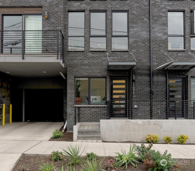 view of exterior entry featuring a balcony