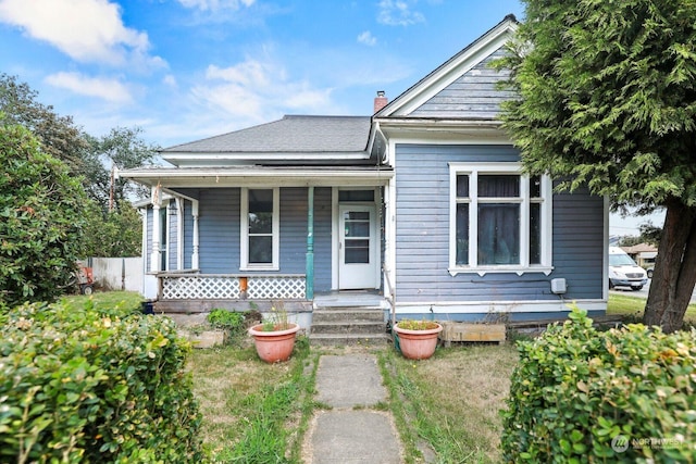 bungalow-style home with covered porch and a chimney