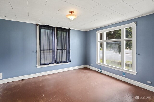 spare room featuring crown molding and concrete flooring