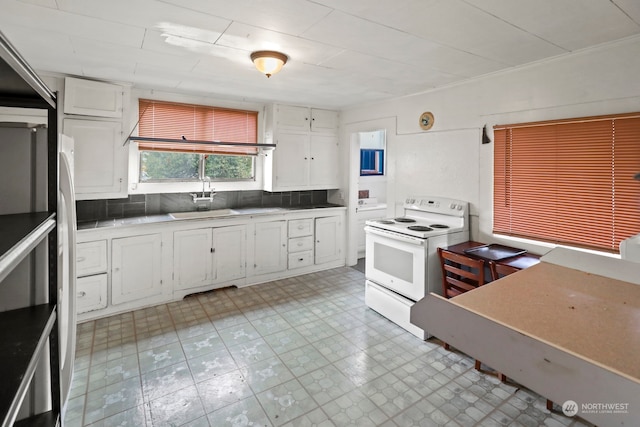 kitchen with backsplash, refrigerator, white electric stove, and white cabinets