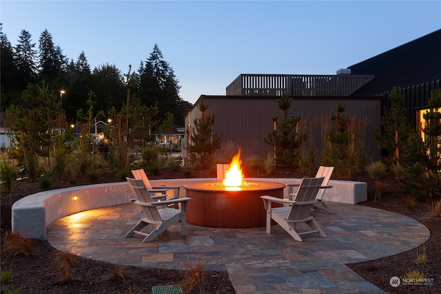 patio terrace at dusk featuring a fire pit