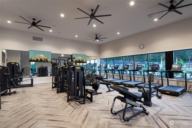 gym with light parquet floors and a towering ceiling