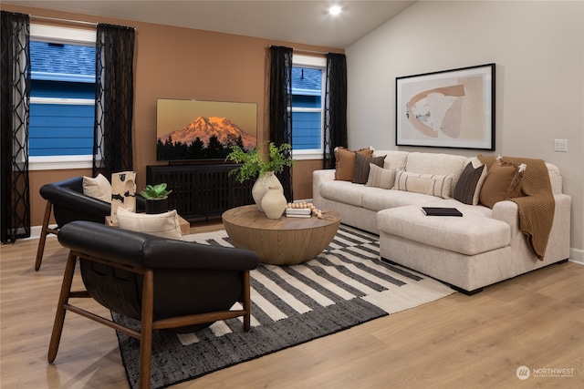 living room featuring light wood-type flooring and lofted ceiling