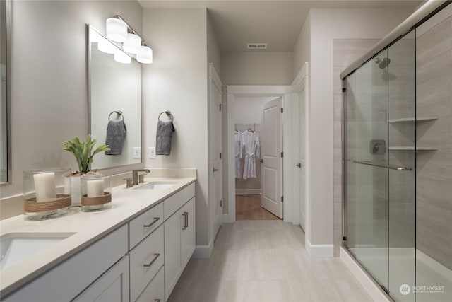 bathroom featuring vanity and a shower with door