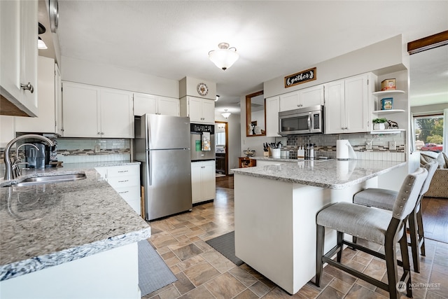 kitchen featuring sink, appliances with stainless steel finishes, and white cabinetry