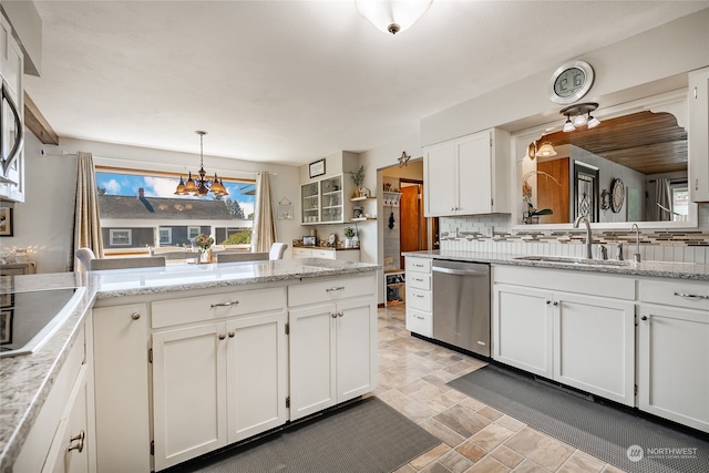 kitchen with white cabinets, dishwasher, sink, pendant lighting, and decorative backsplash