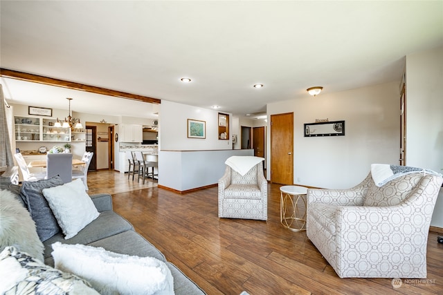 living room featuring an inviting chandelier and dark hardwood / wood-style floors