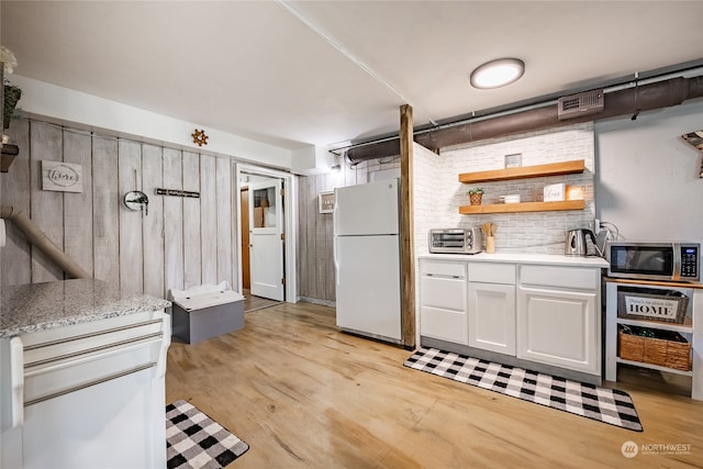 kitchen featuring light hardwood / wood-style floors, white cabinetry, and white fridge