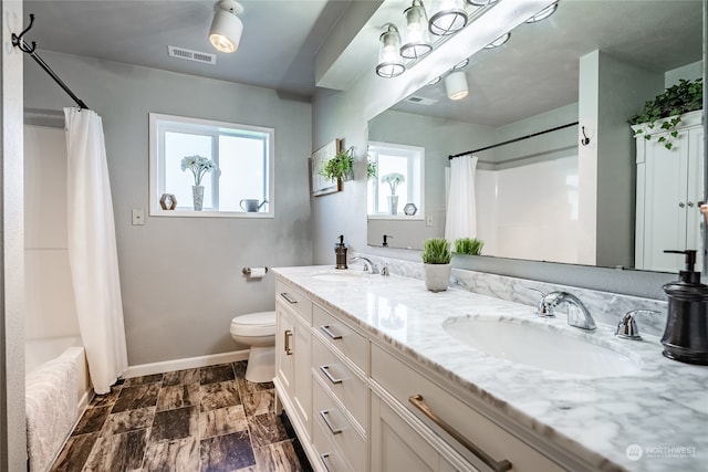 full bathroom featuring toilet, shower / tub combo, and vanity