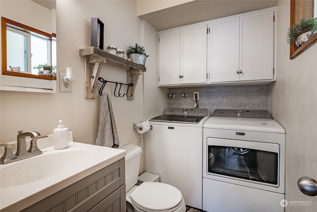 clothes washing area with washing machine and clothes dryer and sink