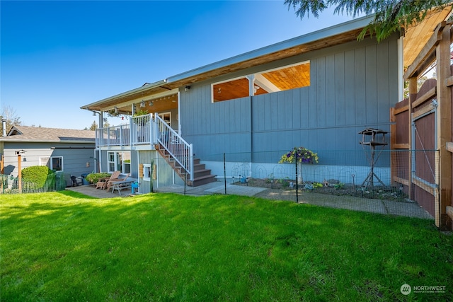 rear view of property featuring a lawn and a patio