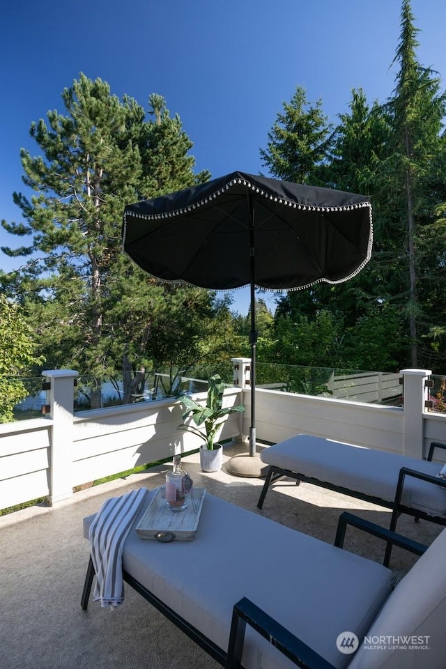 view of patio / terrace with a balcony and fence