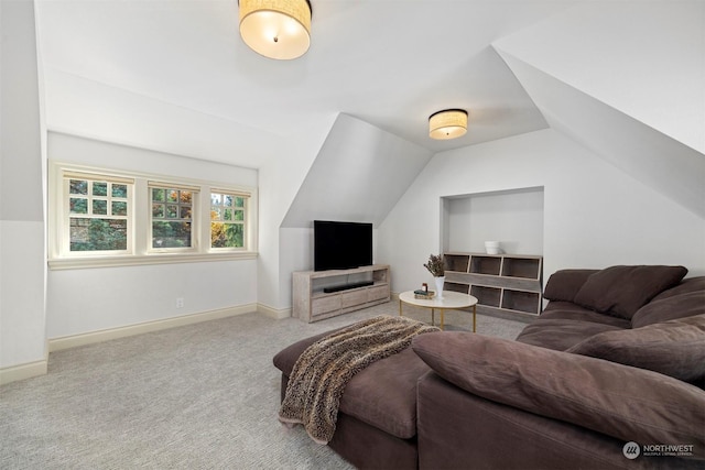 carpeted living room with lofted ceiling and baseboards