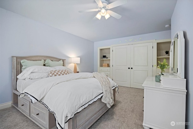 bedroom with baseboards, a closet, a ceiling fan, and light colored carpet