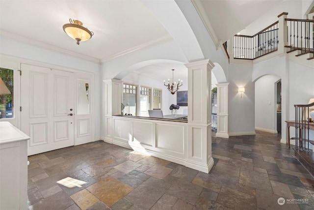 foyer featuring baseboards, stairway, and stone tile floors