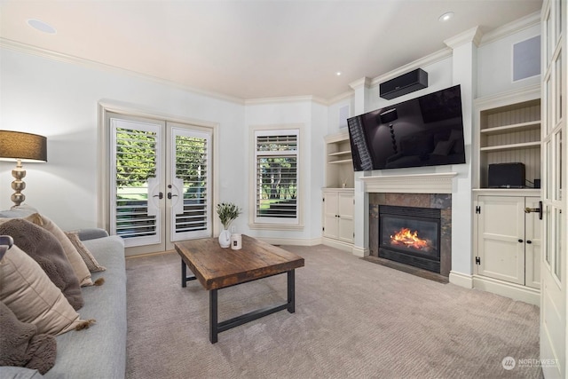 carpeted living area featuring ornamental molding, recessed lighting, french doors, and a fireplace with flush hearth