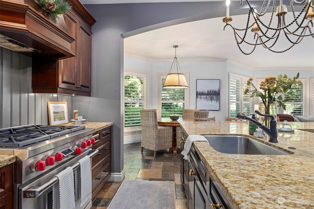 kitchen featuring crown molding, custom range hood, high end range, and stone tile flooring