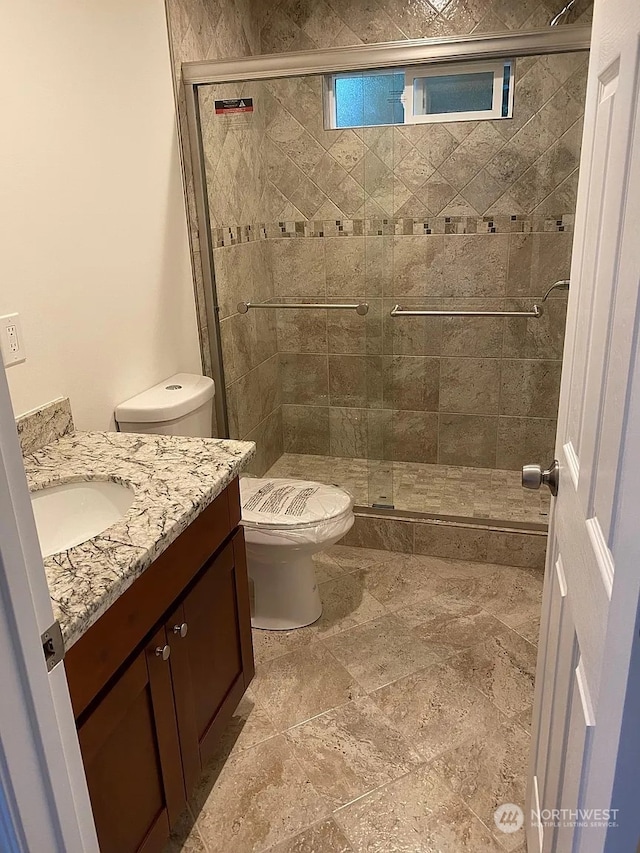 bathroom with vanity, toilet, and an enclosed shower