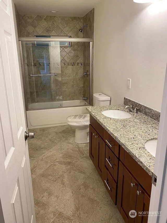 full bathroom featuring shower / bath combination with glass door, vanity, toilet, and tile patterned flooring