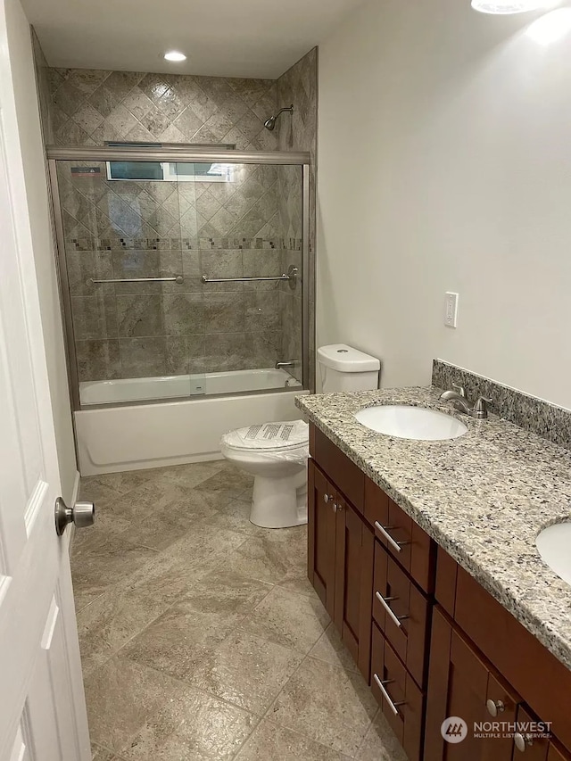 full bathroom featuring combined bath / shower with glass door, vanity, and toilet