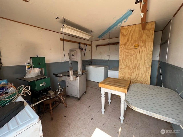 basement featuring wainscoting, separate washer and dryer, fridge, and tile patterned floors