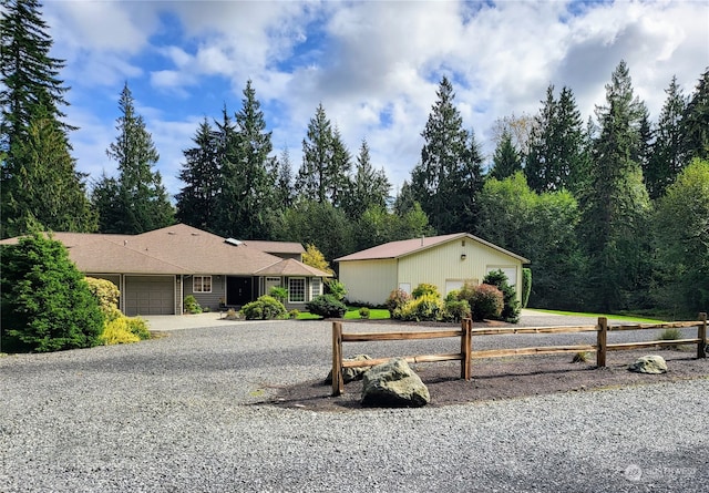 single story home featuring a garage, driveway, and fence