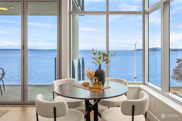 dining room with a water view and light wood-type flooring