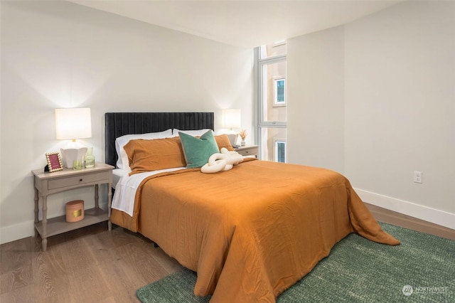 bedroom with baseboards and wood finished floors