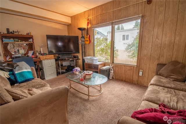 carpeted living room with wood walls