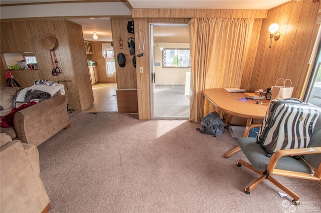 dining area with wood walls and light colored carpet