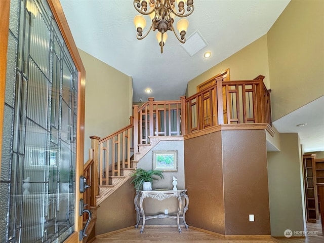 stairs with hardwood / wood-style flooring and a chandelier