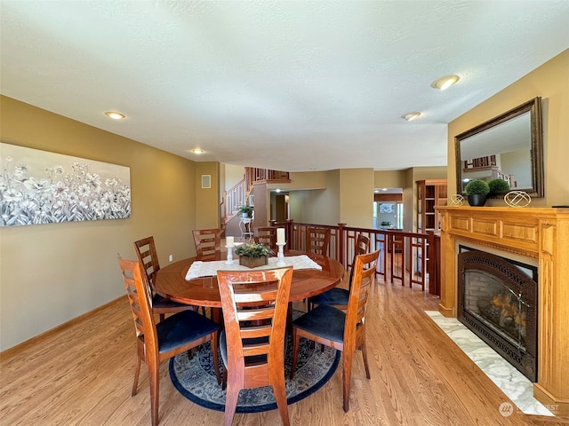 dining area with plenty of natural light, light hardwood / wood-style floors, and a textured ceiling