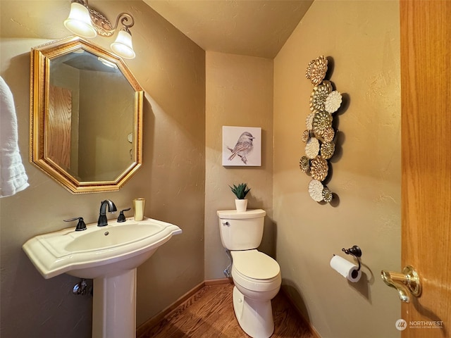 bathroom with toilet and hardwood / wood-style floors