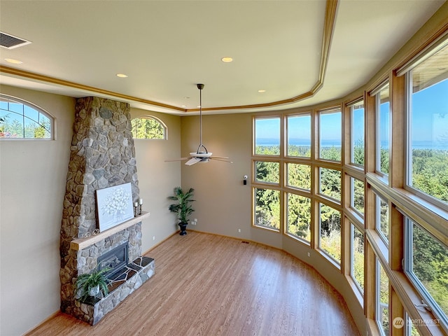 sunroom featuring a fireplace, plenty of natural light, and ceiling fan